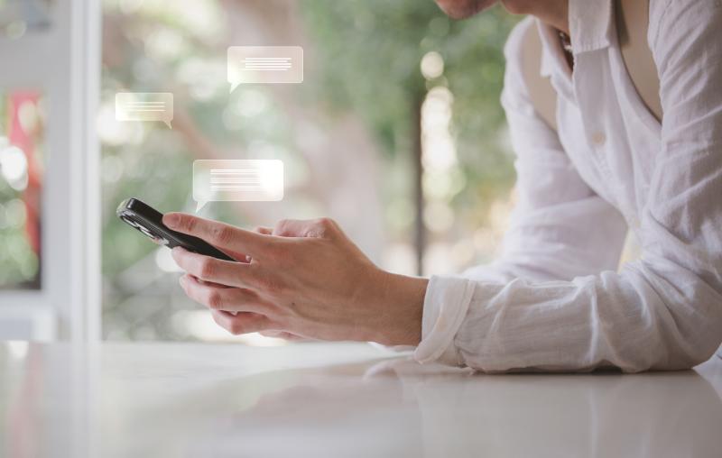 スマートフォンでチャットをする人物
