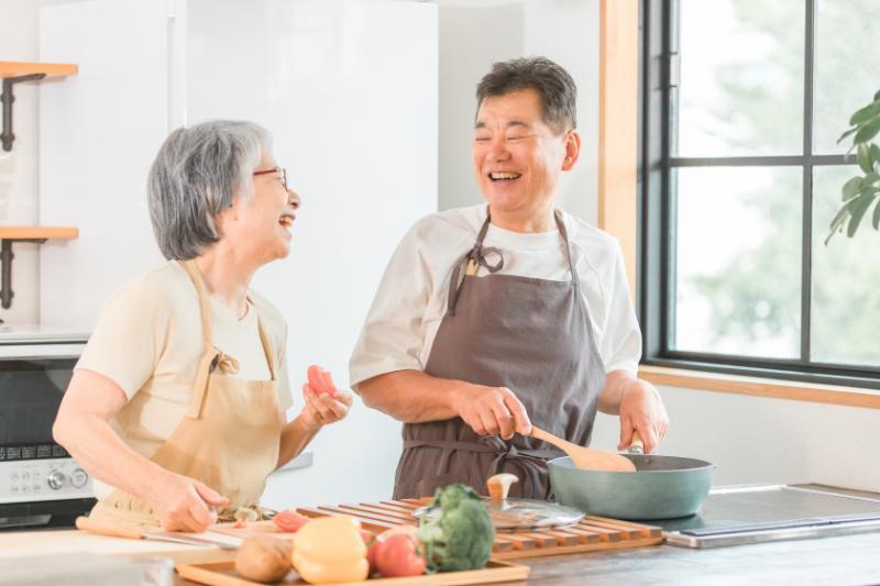 談笑しながら料理するシニア男女