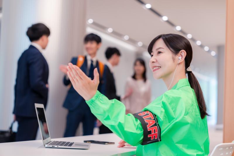 受付で案内をするイベントスタッフの女性