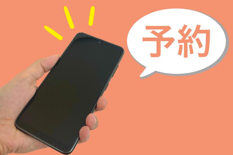 片手で握られたスマートフォンと「予約」と書かれた吹き出し